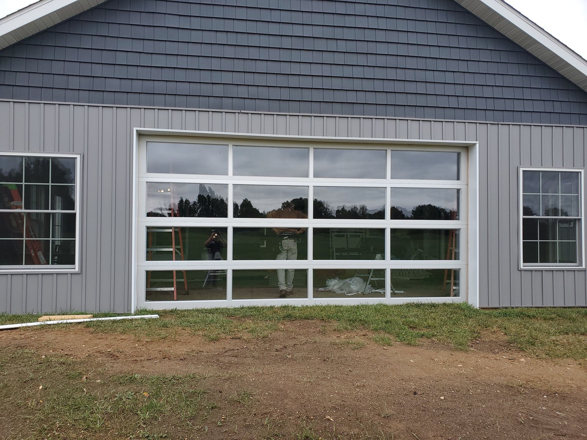 Modern house exterior with a large white garage door and gray siding