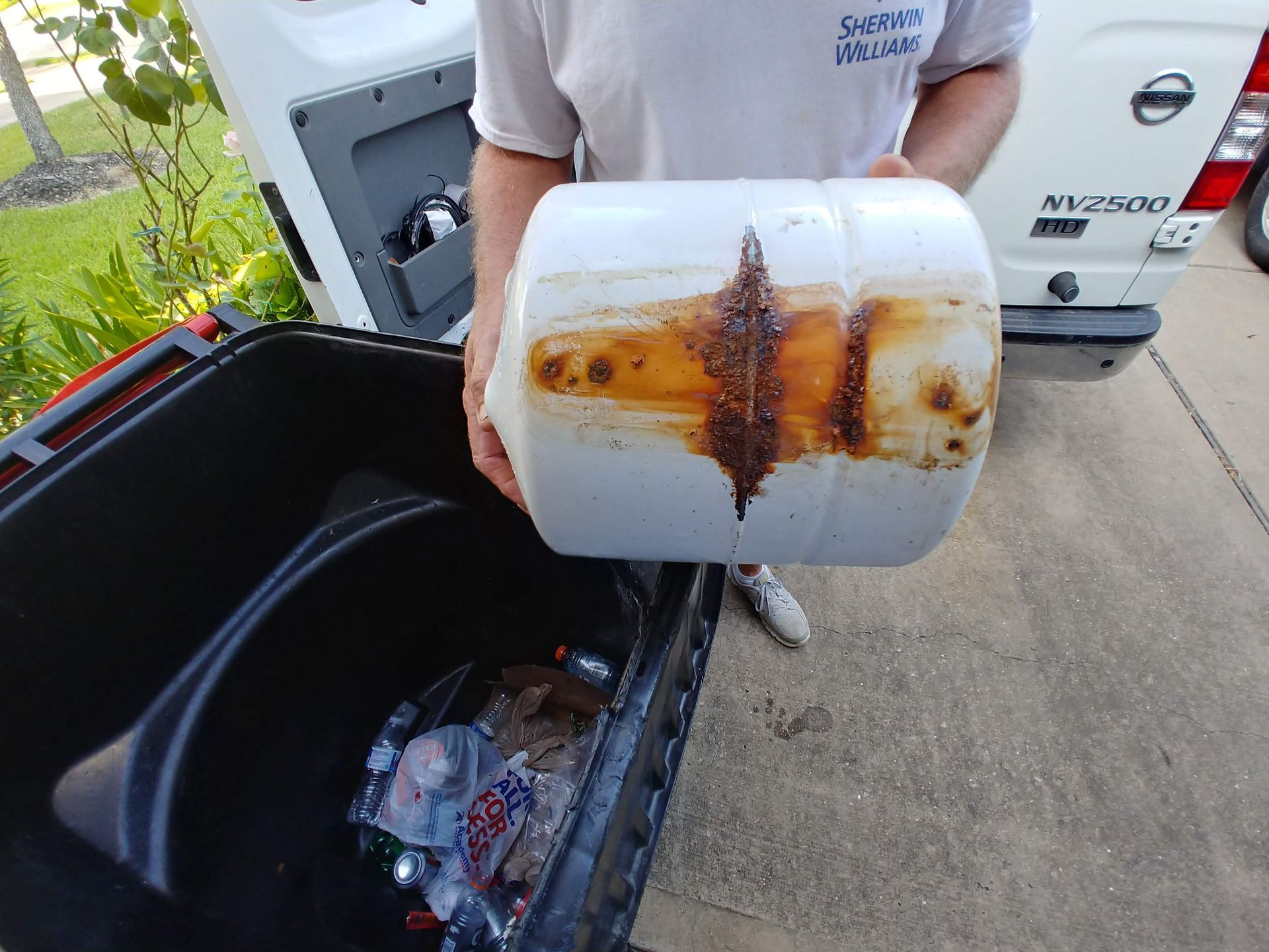 Reverse osmosis storage tank with heavy rust and corrosion on the bottom, showing improper installation and risk of contamination.