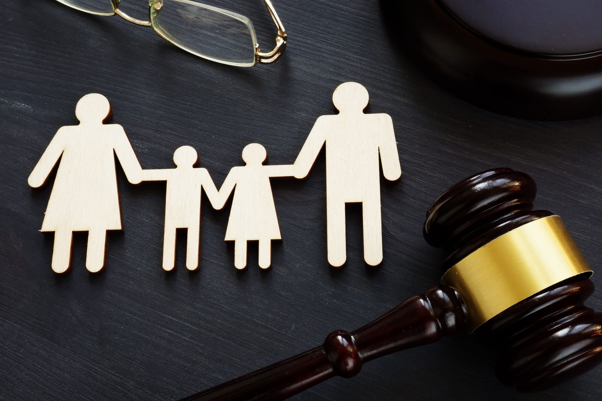 Paper family figures beside a judge’s gavel, symbolizing family law or custody decision