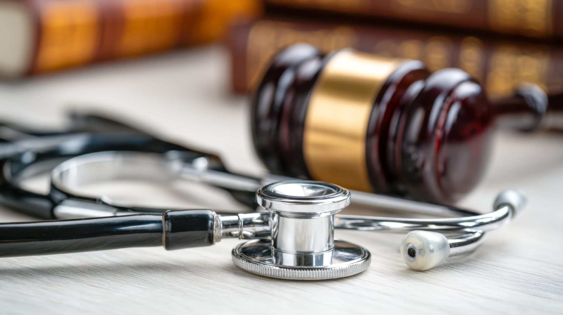 Stethoscope beside a judge’s gavel on a desk, symbolizing medical malpractice or legal medicine.