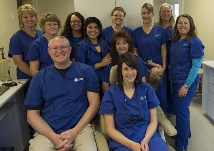 A group of people in blue scrubs are posing for a picture