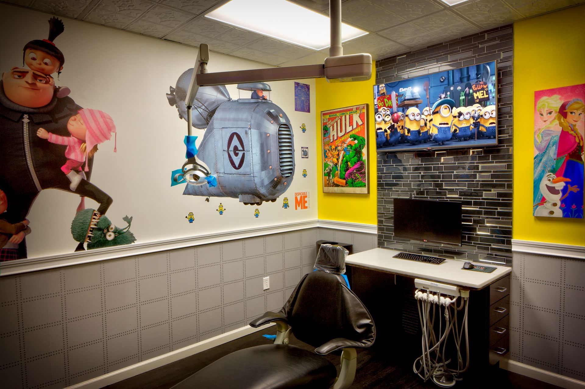 Colorful gaming room with computer desk, monitor, black chair, and cartoon wall art.