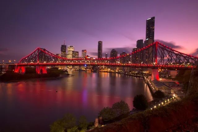 A Bridge Over A Body Of Water With A City In The Background At Night — Haydyn's Cleaning In Kawungan, QLD