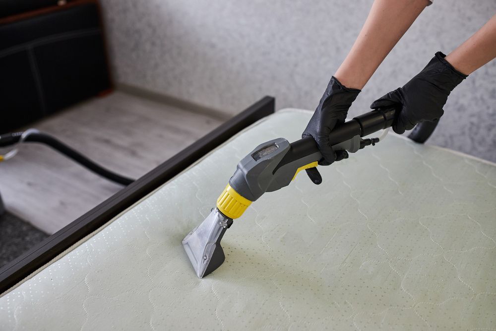A Person Is Cleaning a Mattress with A Vacuum Cleaner — Haydyn's Cleaning In Craignish, QLD