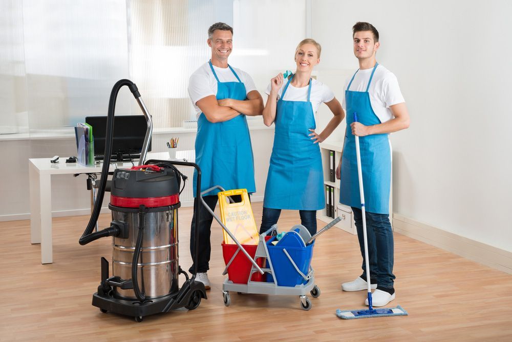 A Group of Cleaners Are Standing Next to Each Other in An Office — Haydyn's Cleaning In Craignish, QLD