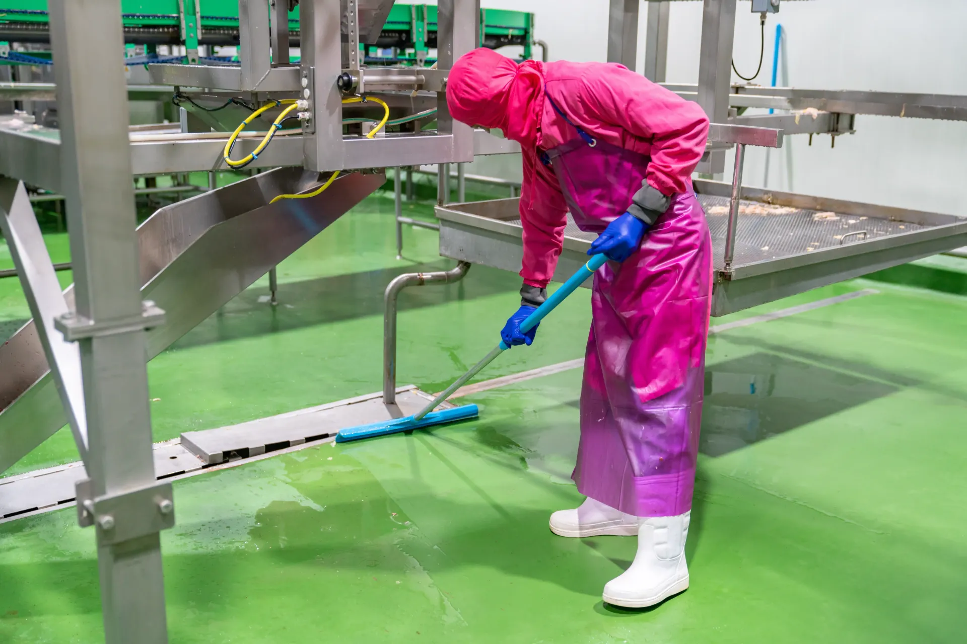 Worker in Protective Gear Cleaning a Green Factory Floor — Haydyn's Cleaning In Urraween, QLD