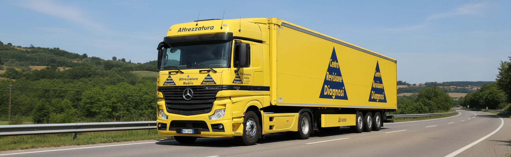 Un camion giallo brillante che percorre una strada tortuosa con un cielo azzurro sullo sfondo.