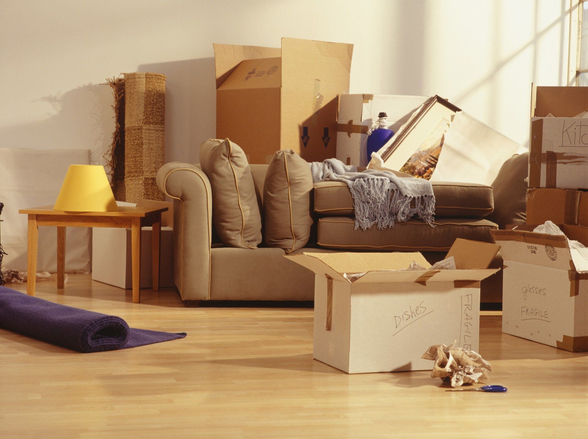 A living room filled with cardboard boxes and a couch