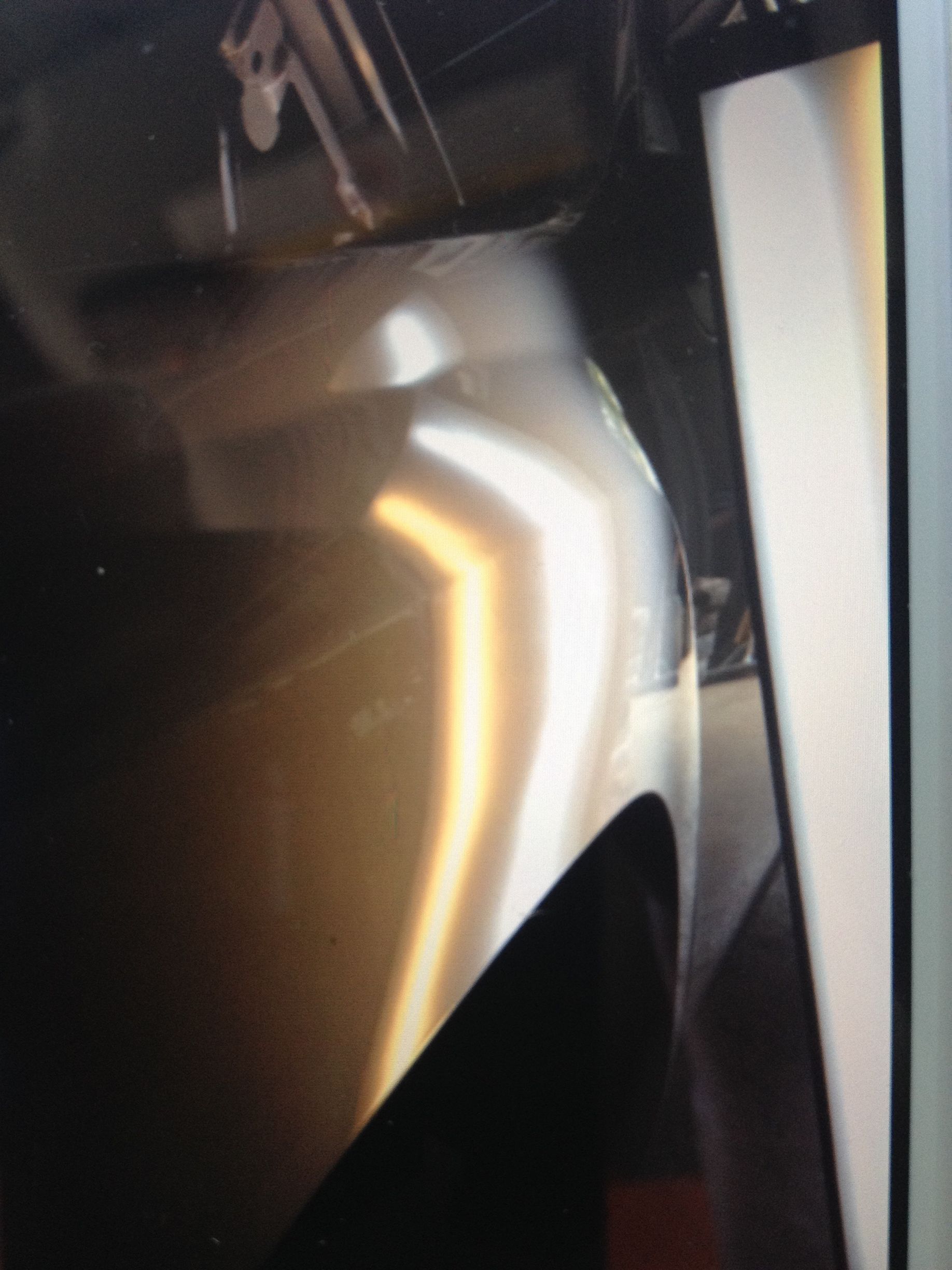 A close up of a car fender with a dent in it