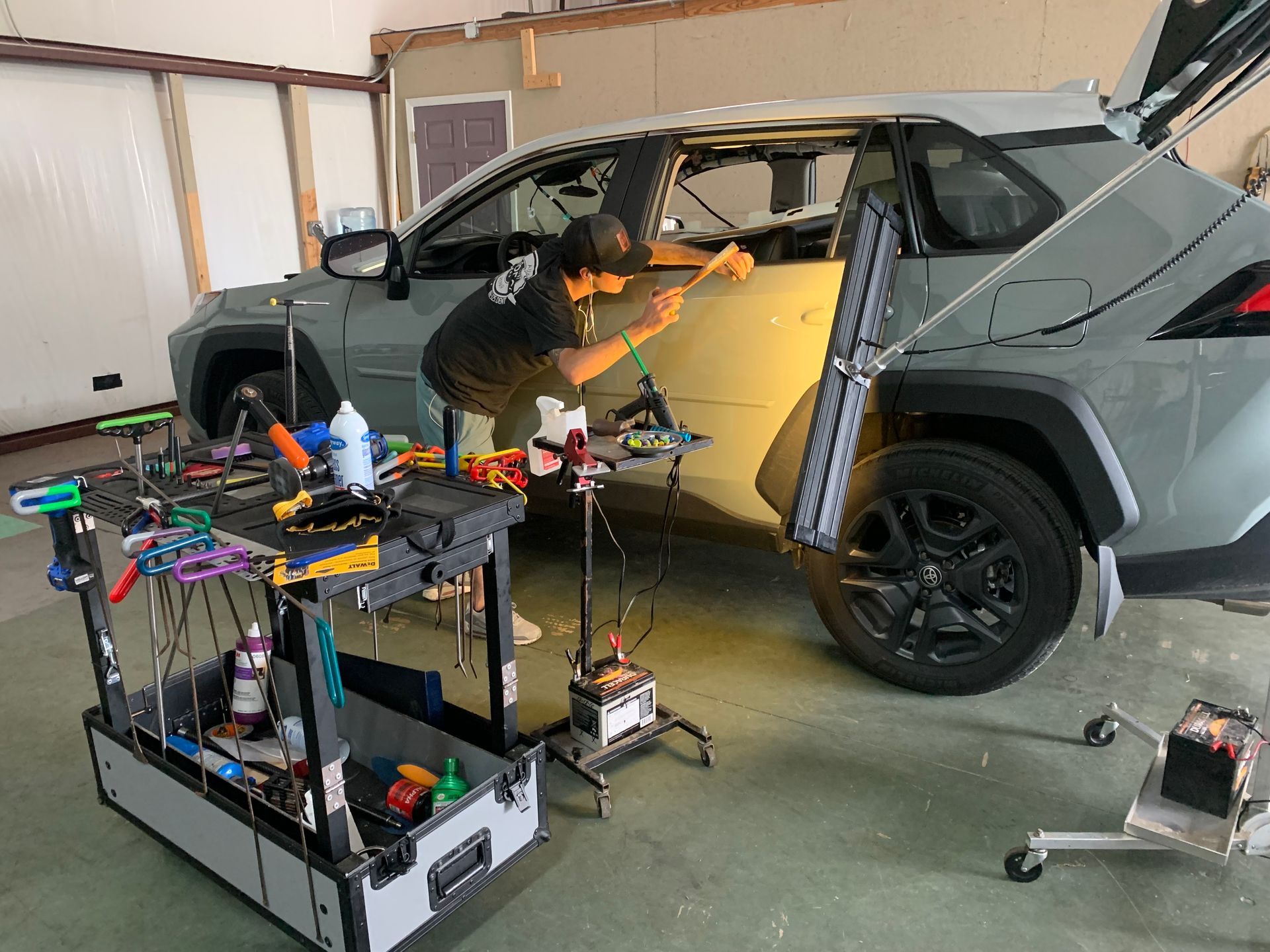 A man is working on a car in a garage.
