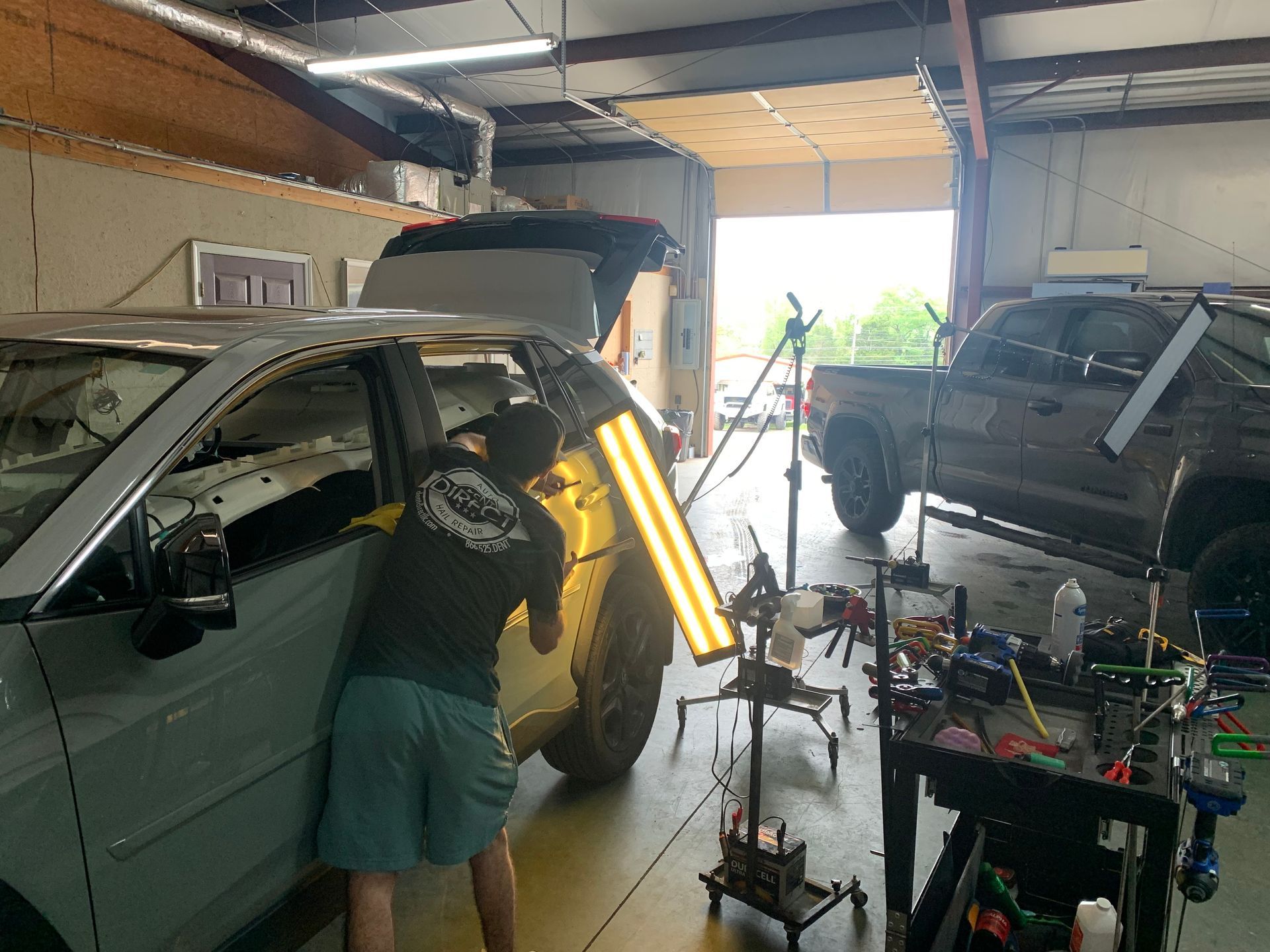 A man is working on a car in a garage.