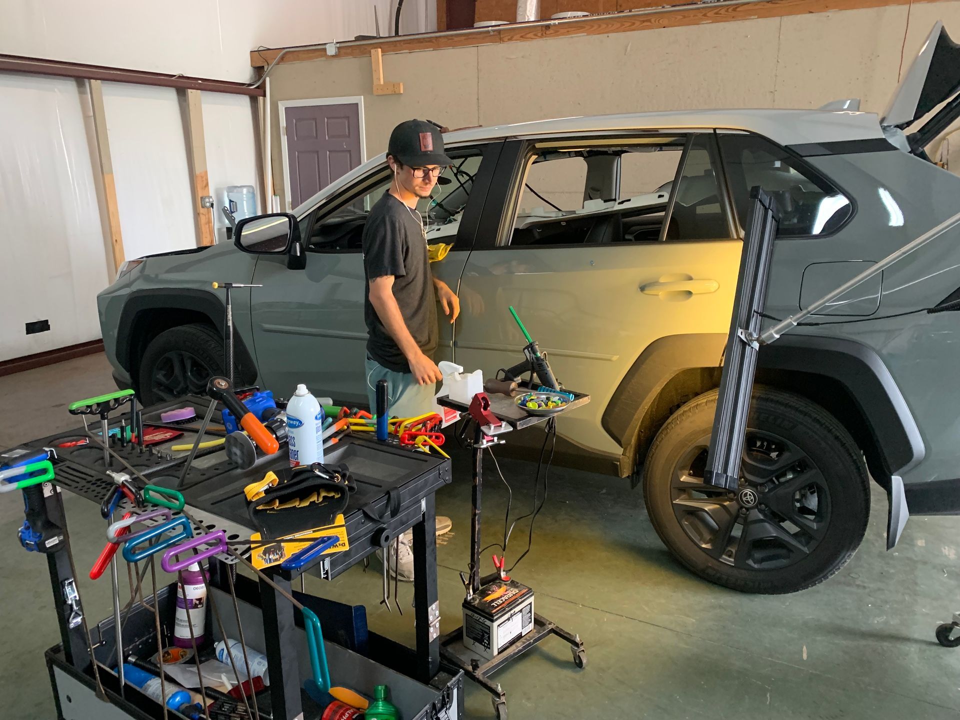 A man is working on a car in a garage.