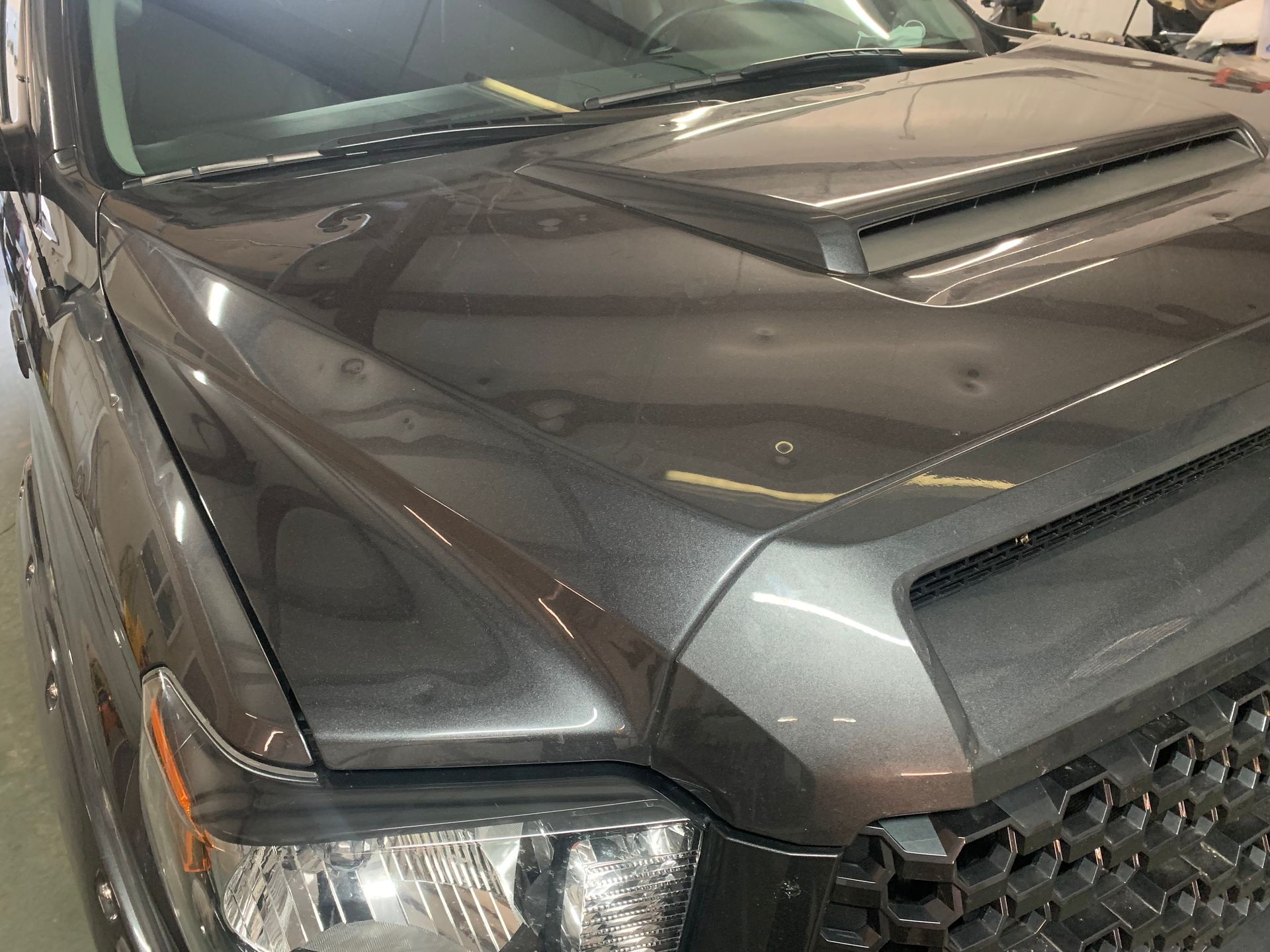 A close up of the hood of a toyota tundra in a garage.