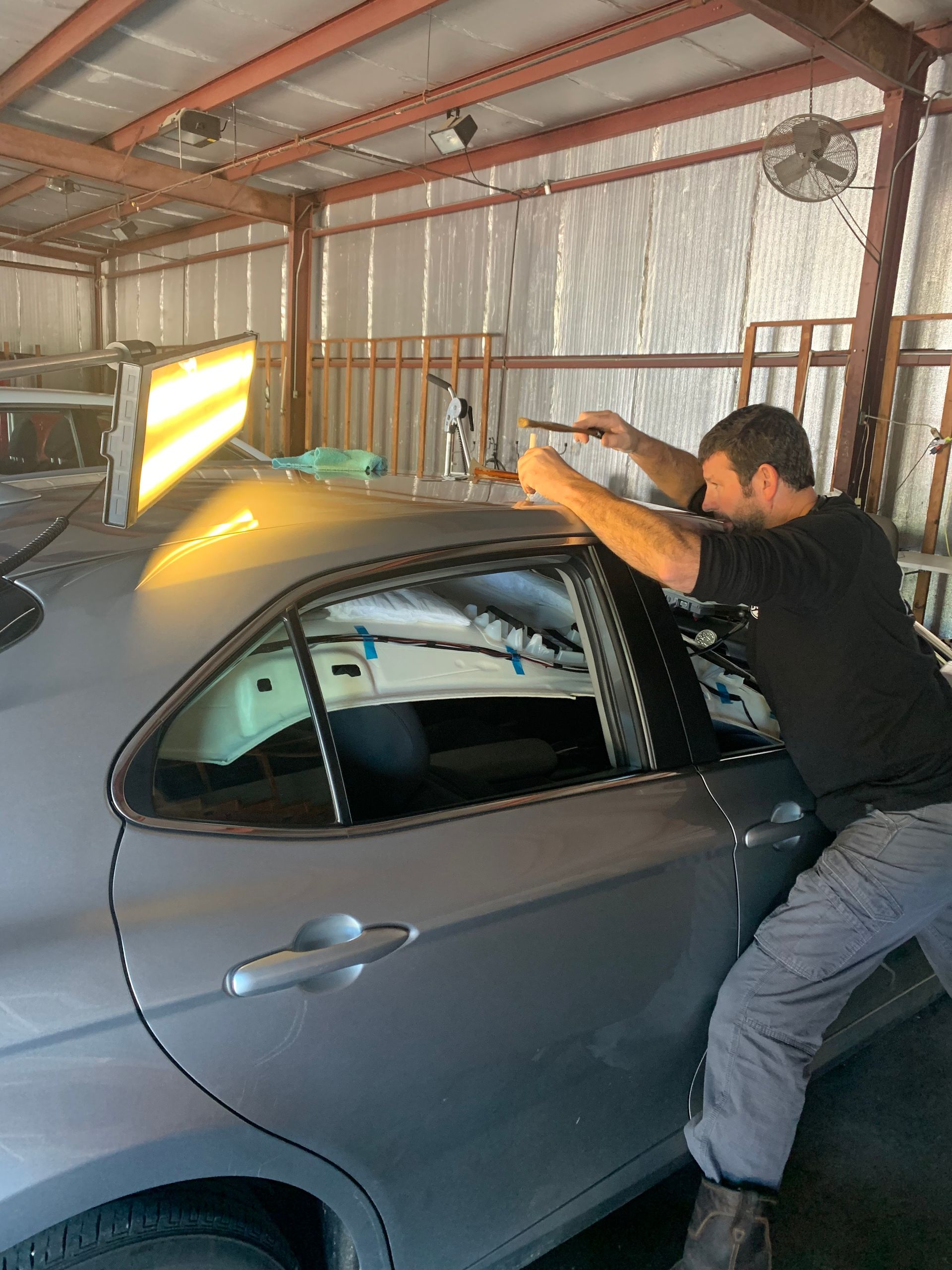 A man is working on a car in a garage.