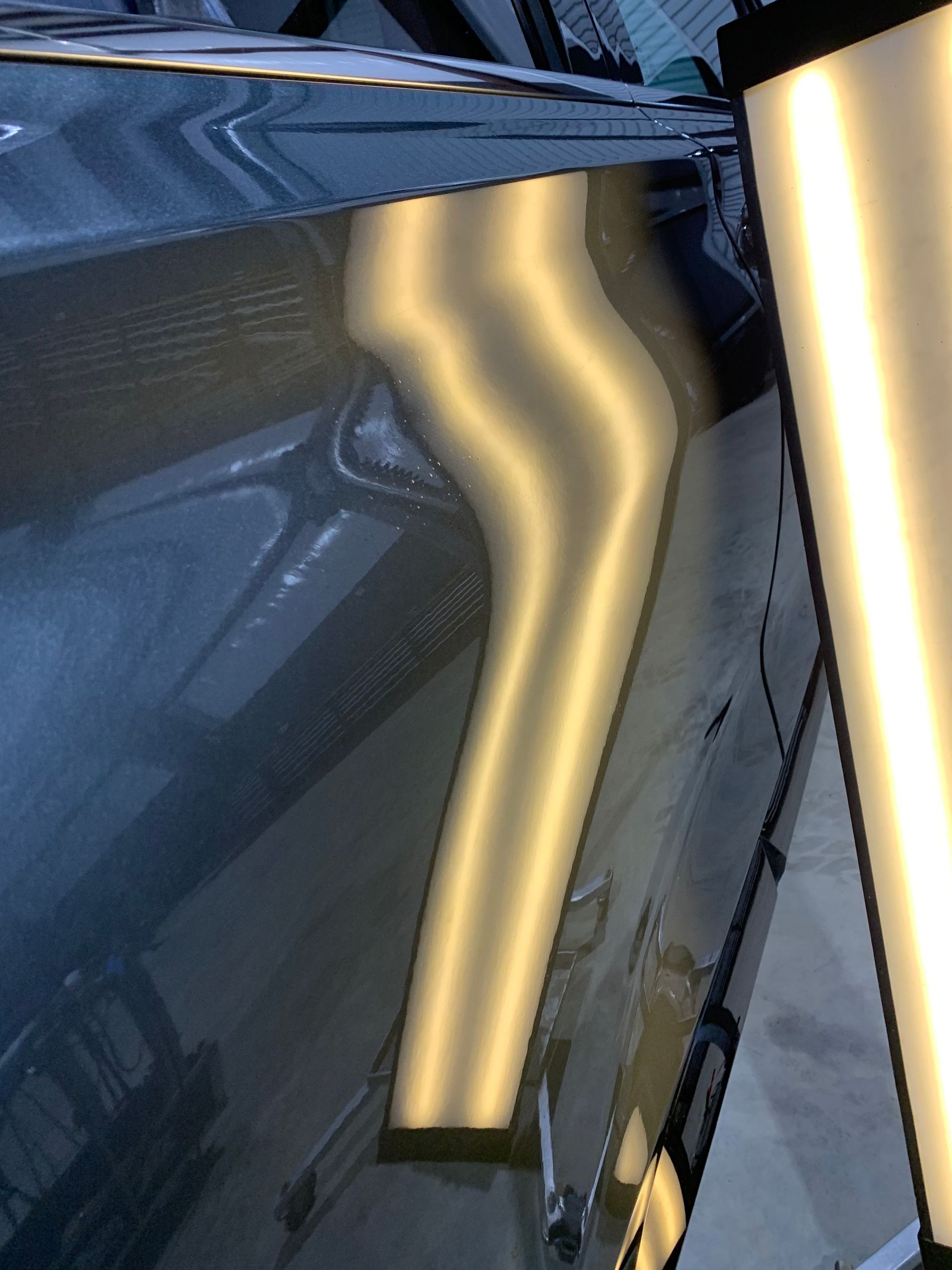A close up of a car with a dent on the side of it.