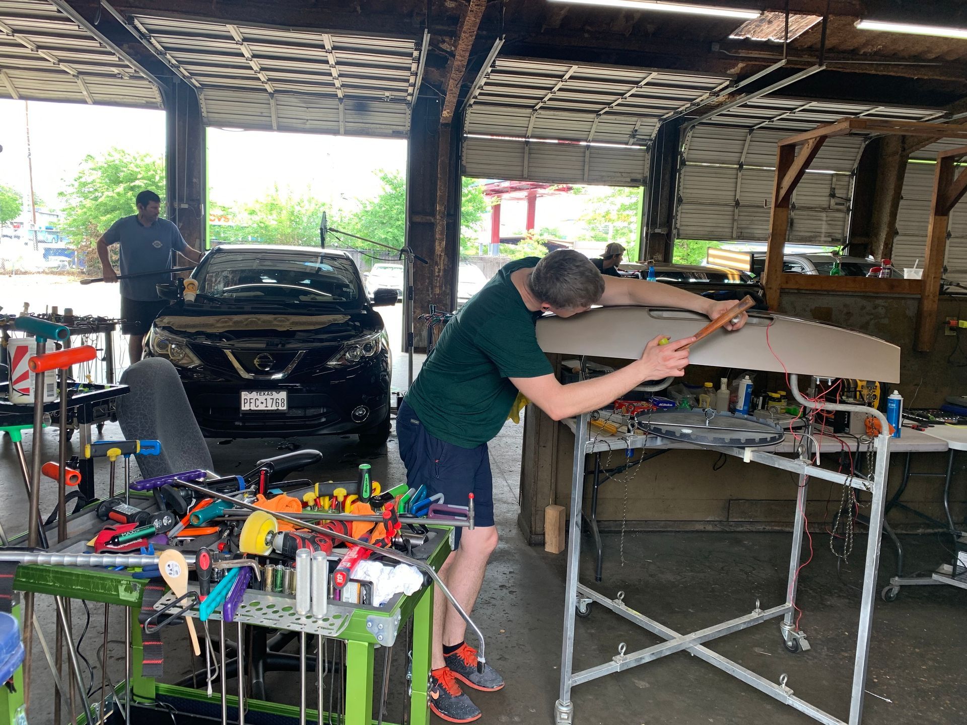 A man is working on a car in a garage.