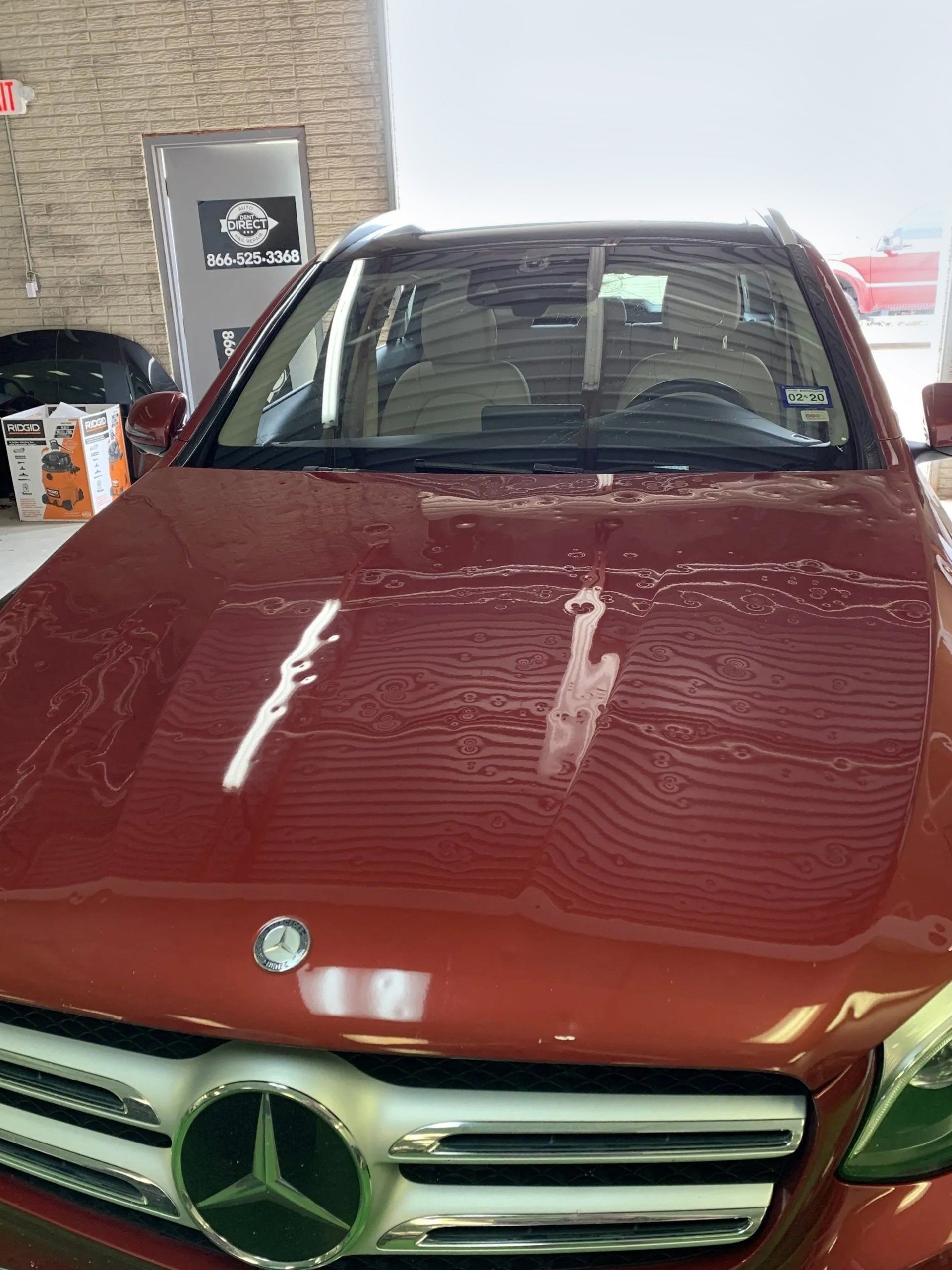 A red mercedes benz suv is parked in a garage.