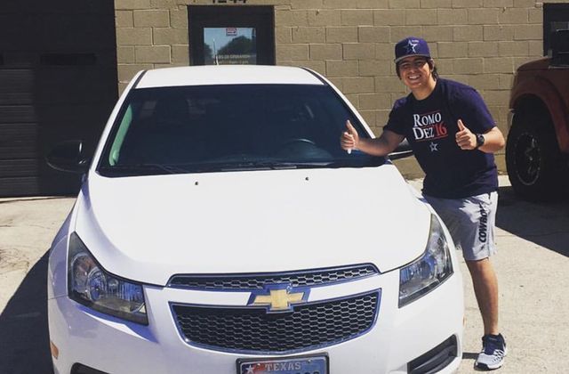 A man is standing in front of a white chevrolet car