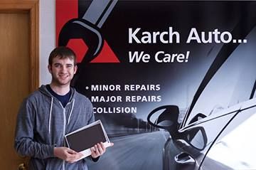 Our mechanic posing with a banner in State College, PA | Karch Auto