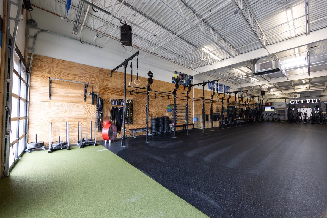 A large empty gym with a lot of equipment in it.