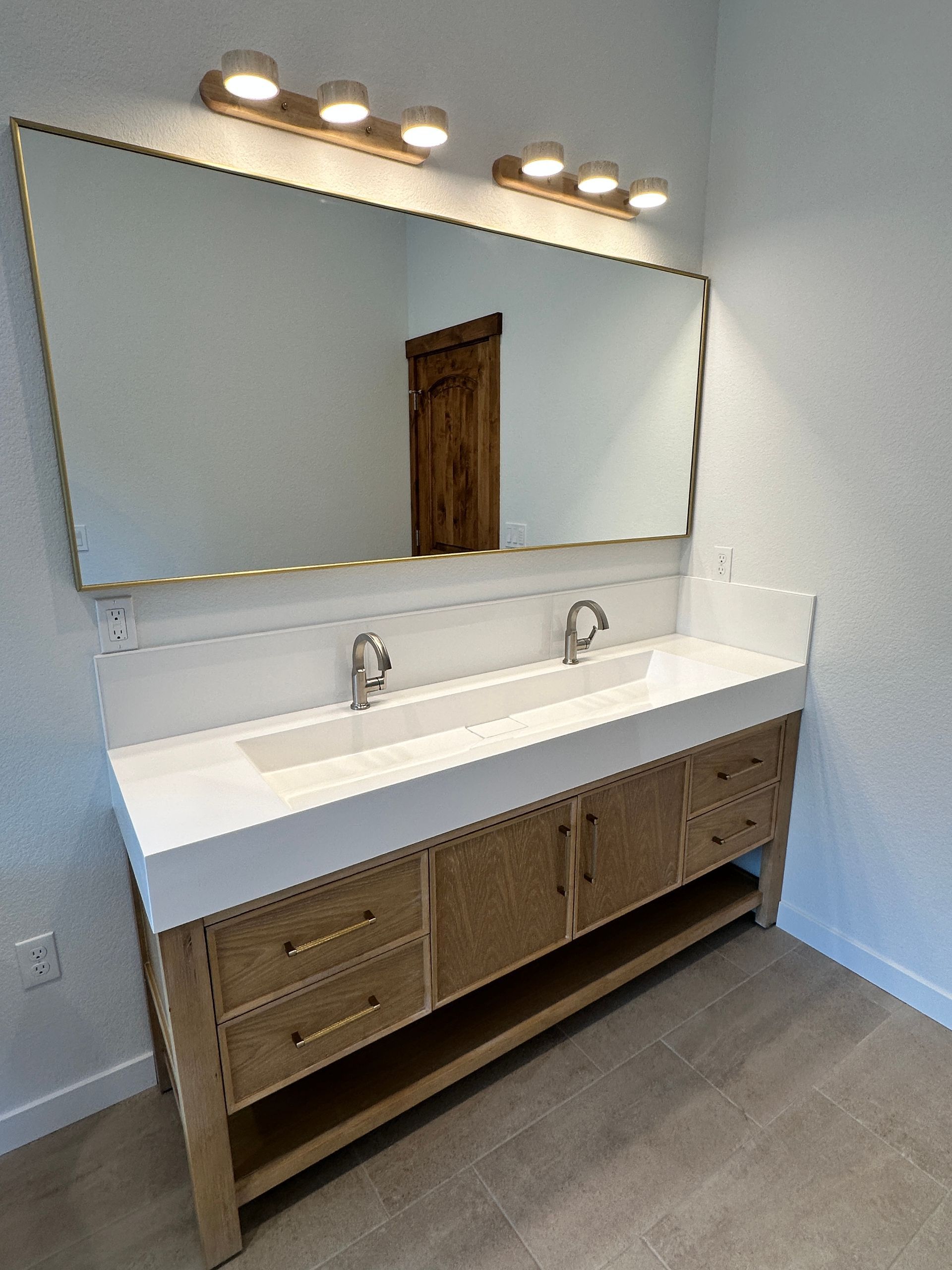 A bathroom with two sinks and a large mirror