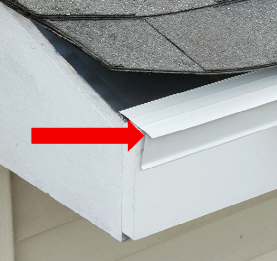 Red arrow pointing to roof edge flashing where shingles meet white trim