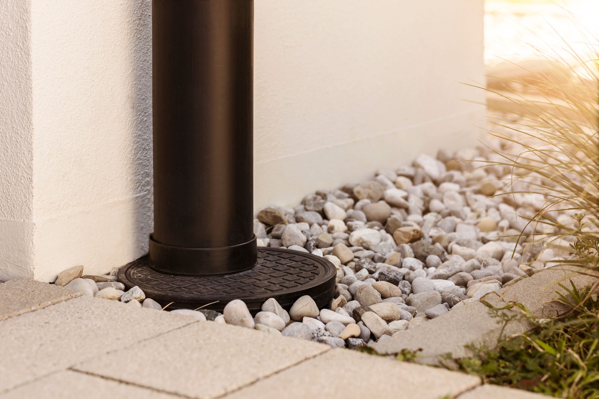 A drainpipe is attached to the side of a brick building.