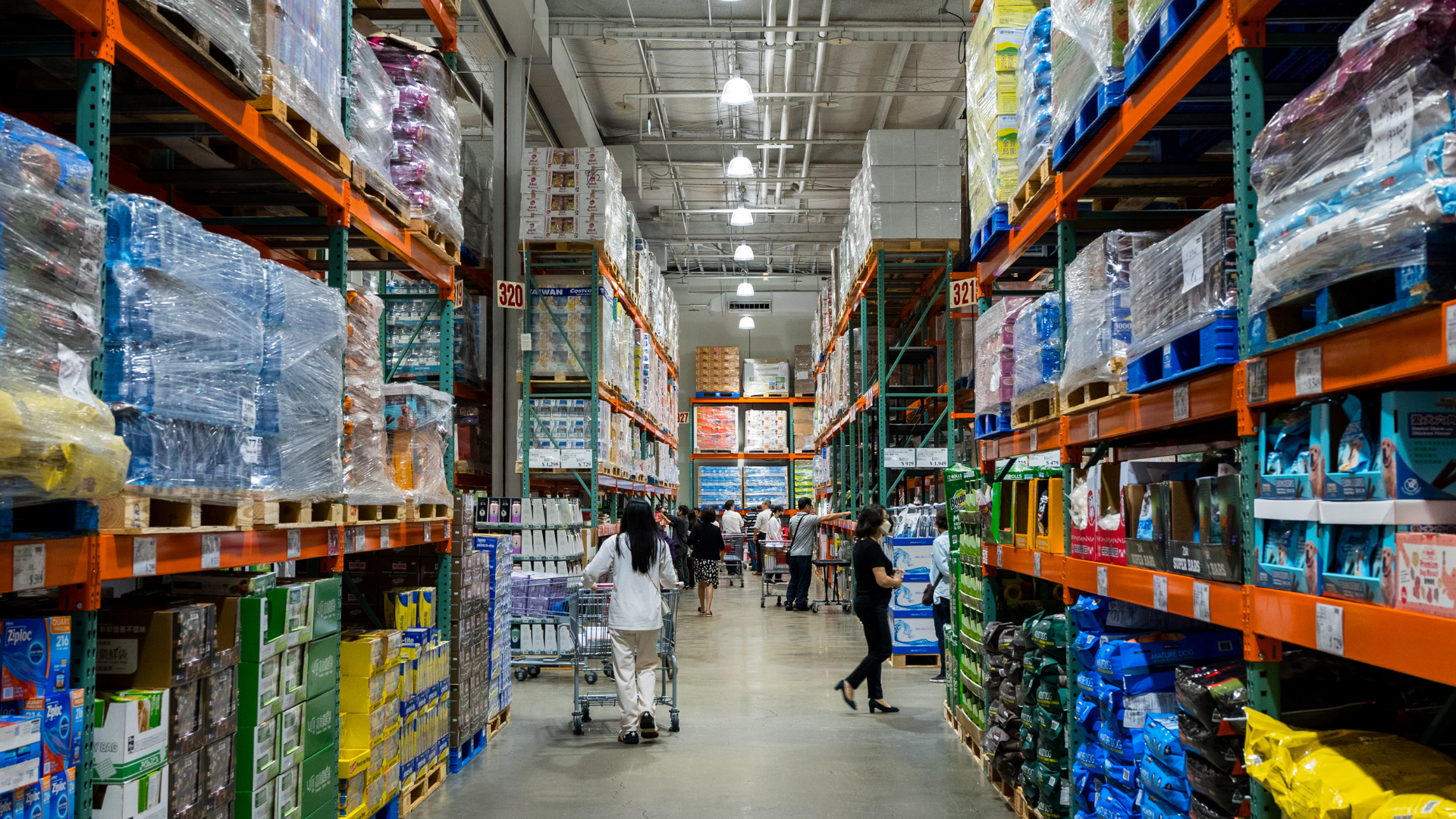 A large warehouse filled with lots of products and people shopping.