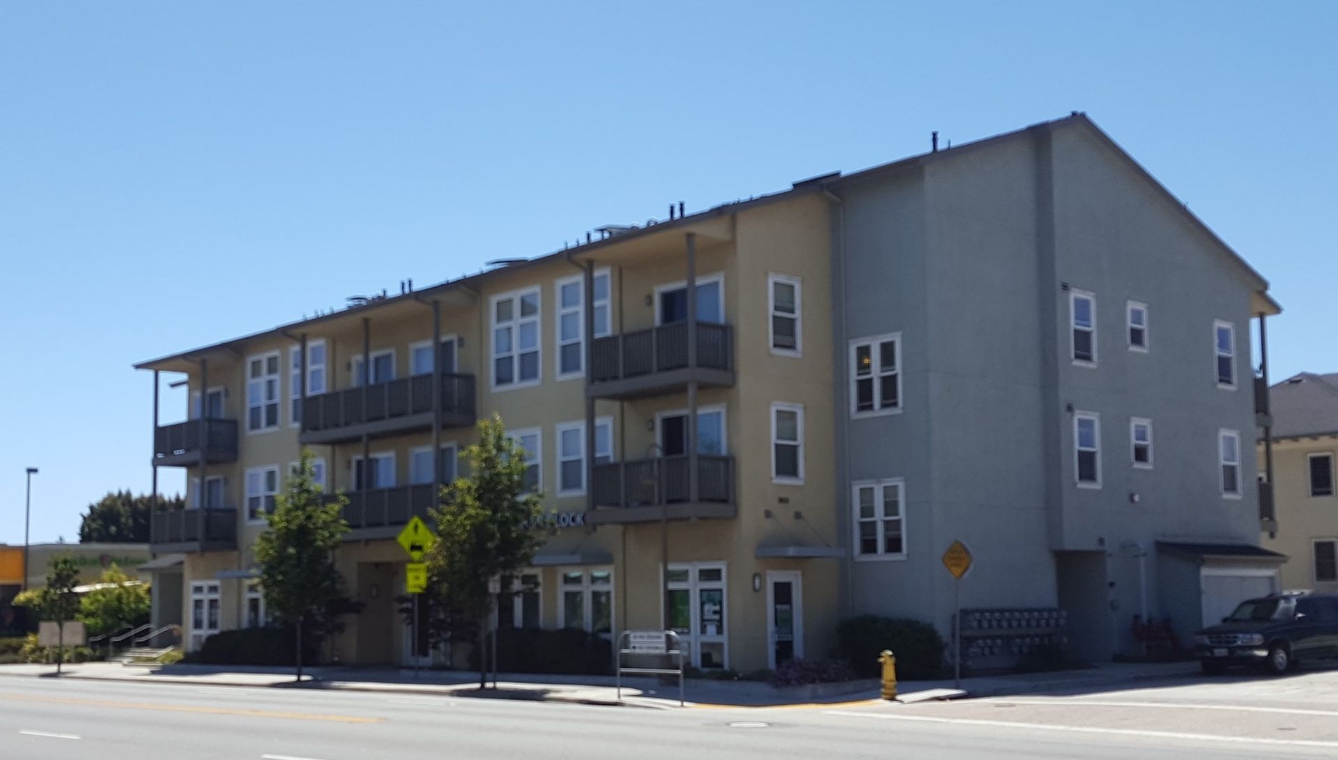 A large apartment building with a lot of windows and balconies on a sunny day.