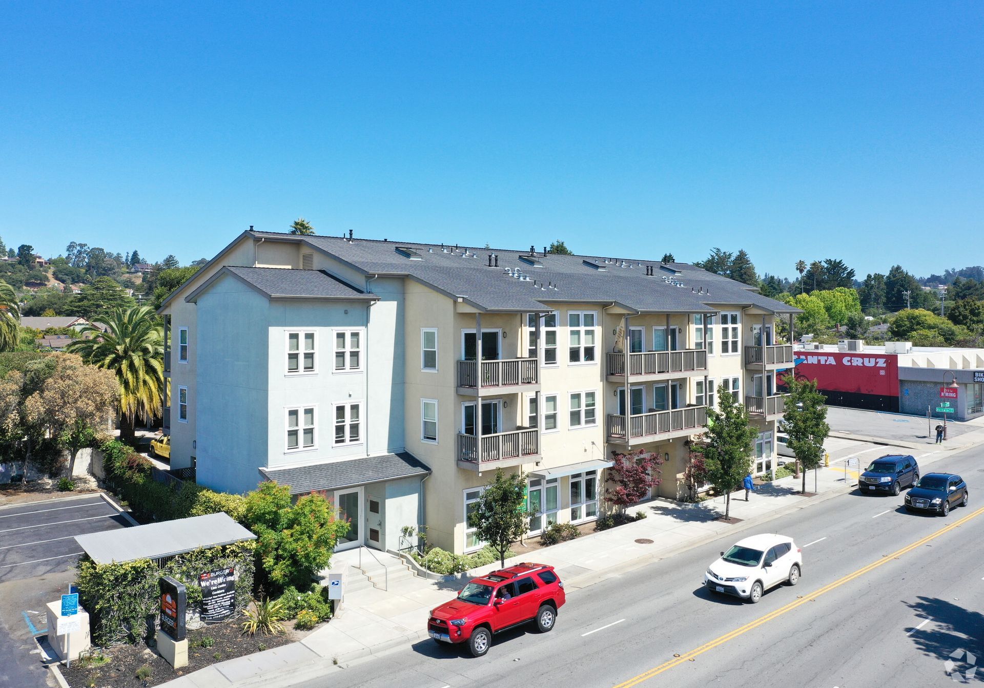 An aerial view of a building with a red suv parked in front of it.