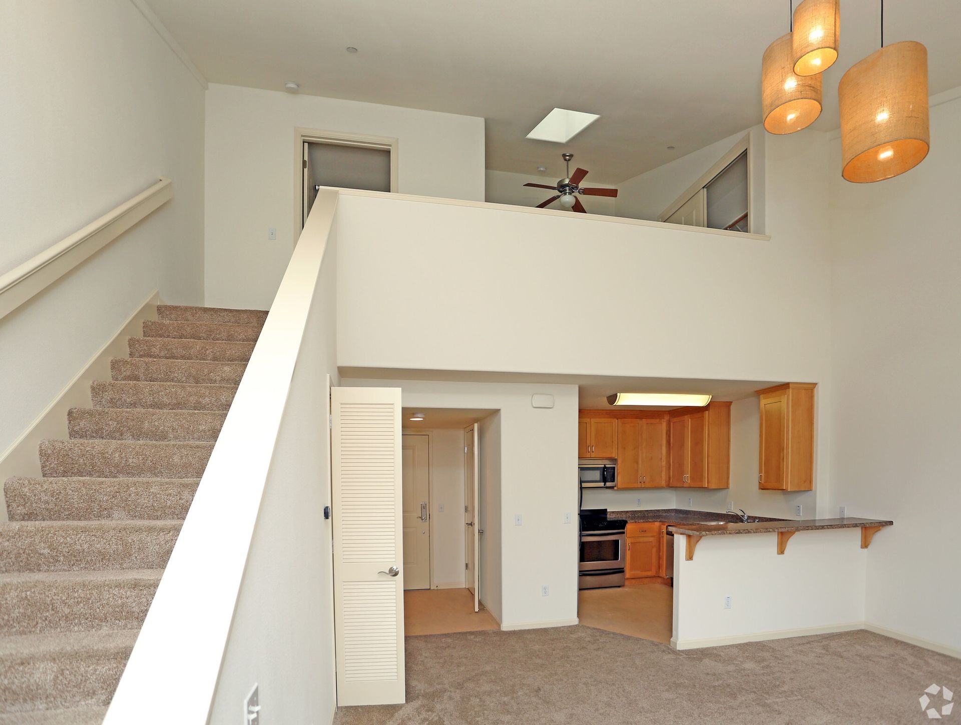 A living room with stairs leading up to the second floor
