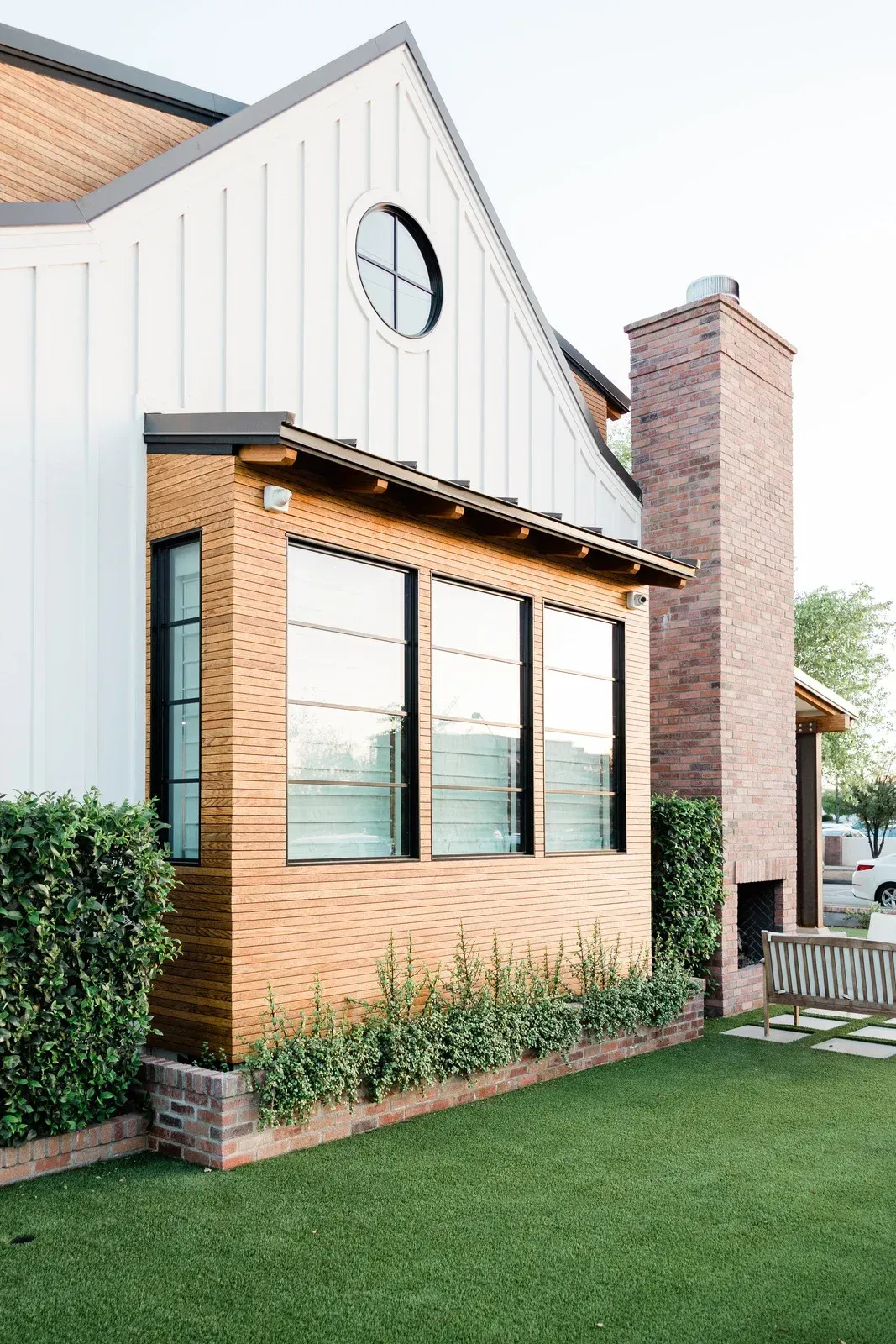A house with a lot of windows and a chimney on the side of it.
