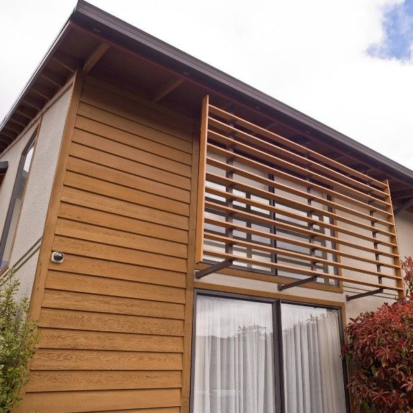 Modern wooden house exterior with slatted balcony and large windows