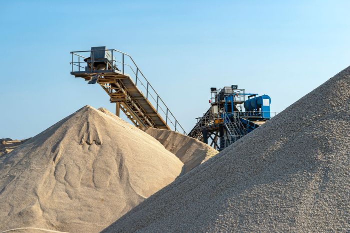 Conveyor belt over heaps of gravel against the blue sky