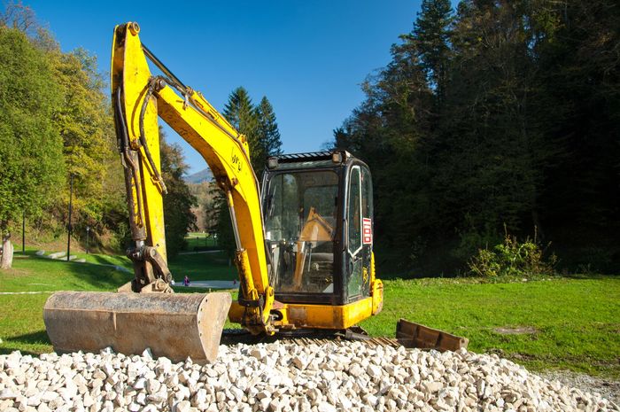 Yellow mini excavator on a construction site