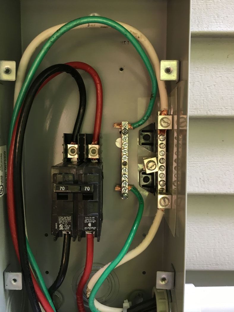 Open electrical breaker panel with wires and terminals inside a metal box