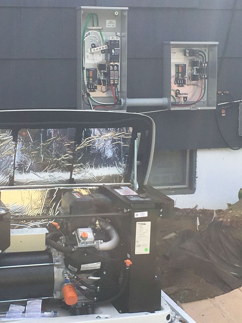 Outdoor generator setup beside a building, with open electrical panels and a fuel tank in front.