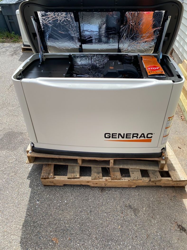 Open Generac generator on a wooden pallet outdoors, with orange control panel visible.