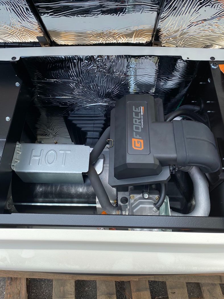 Car engine bay with a black aftermarket component and silver parts beneath an open hood