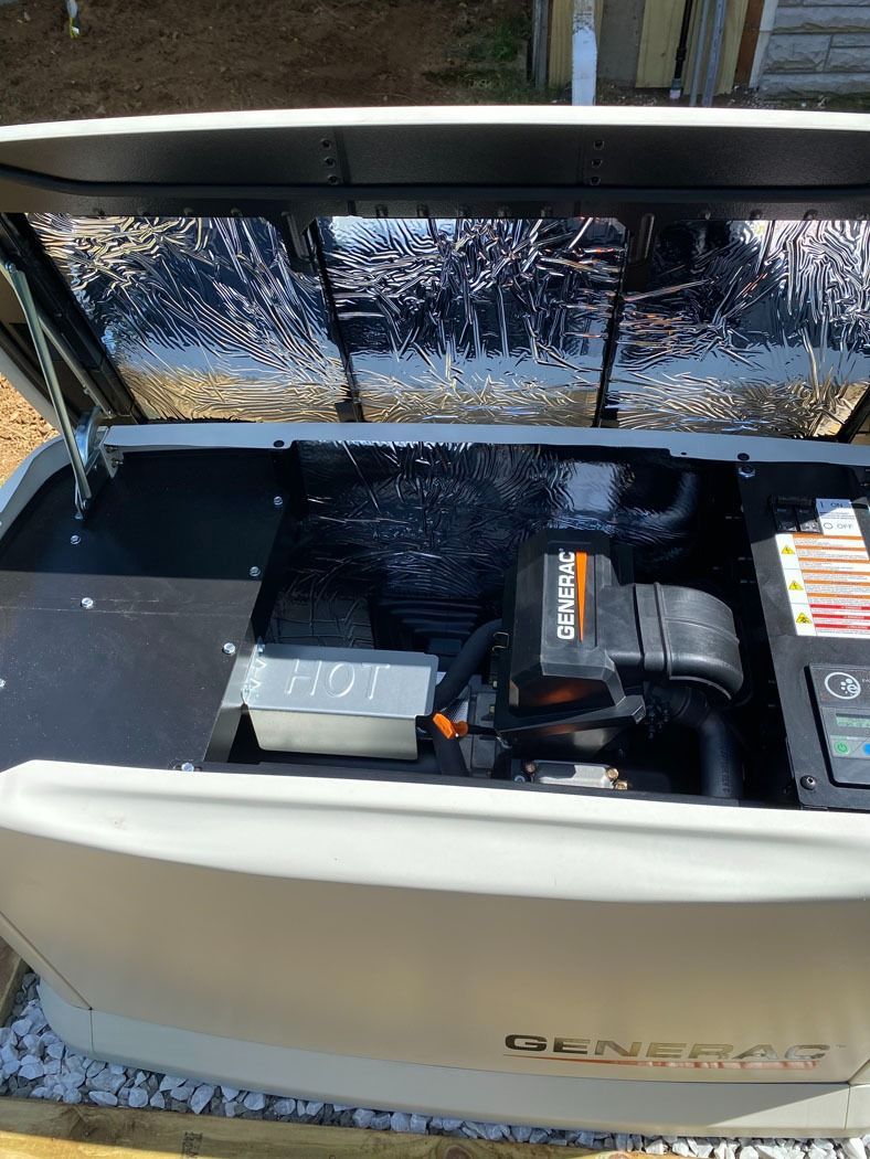 Open utility compartment with black engine and gray battery inside a white boat stern