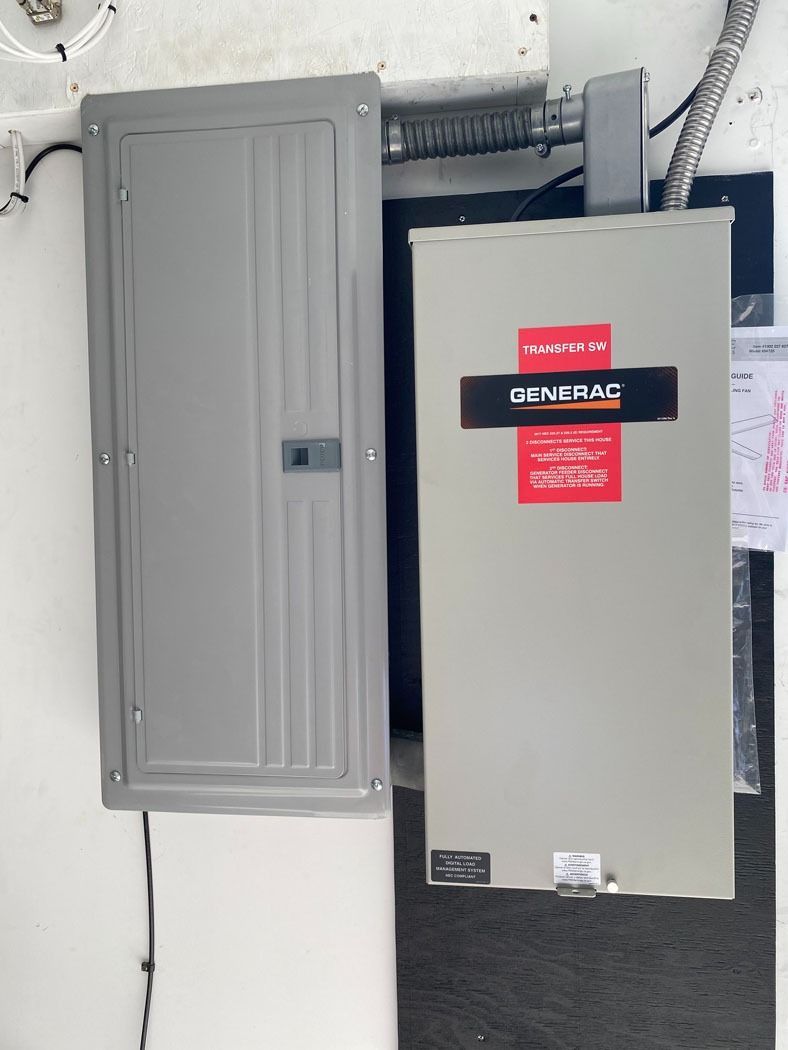 Two gray electrical panels mounted on a wall, one open and one closed.