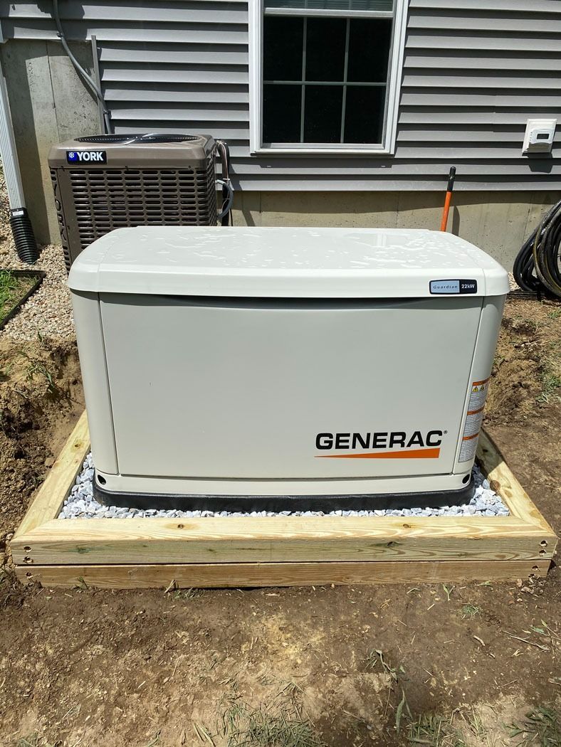 White Generac backup generator on a wooden platform beside a house exterior.