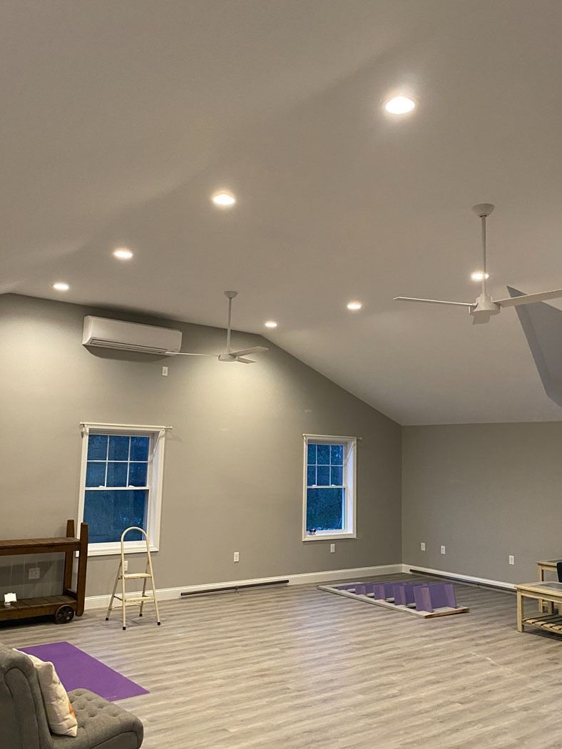 Partially finished gray room with recessed lights, ceiling fan, windows, and ladder on a new floor