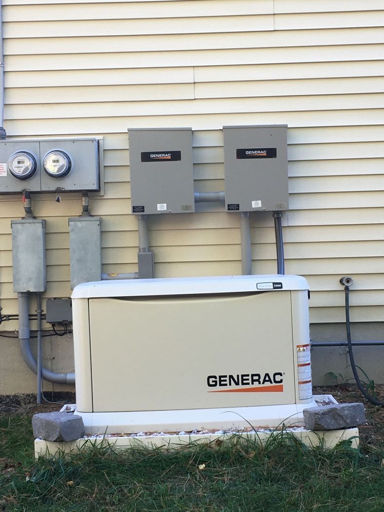 Generac home generator beside utility meters on a house exterior wall