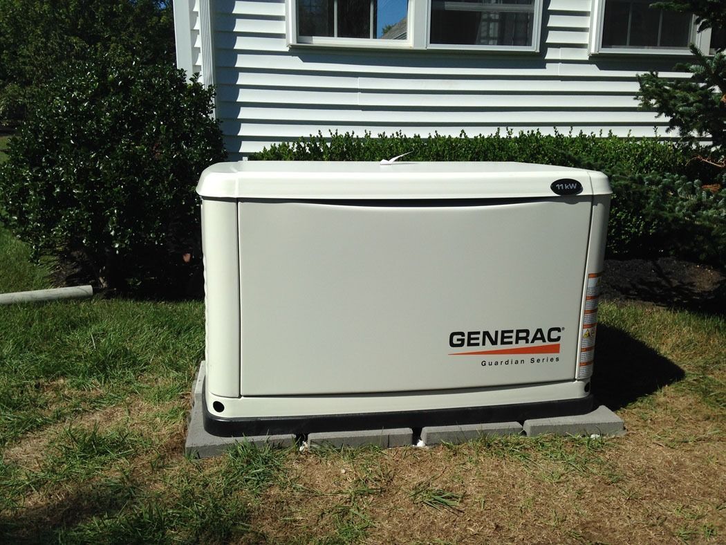 Generac standby generator beside a house on a grassy lawn