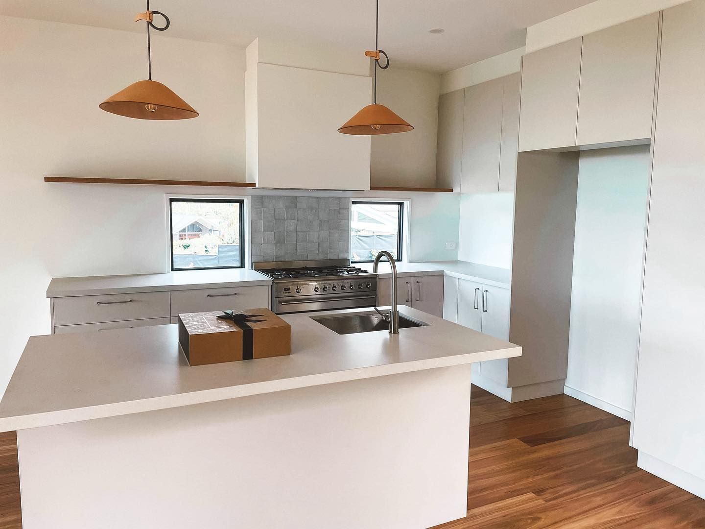 A kitchen with white cabinets , a sink , and a stove.