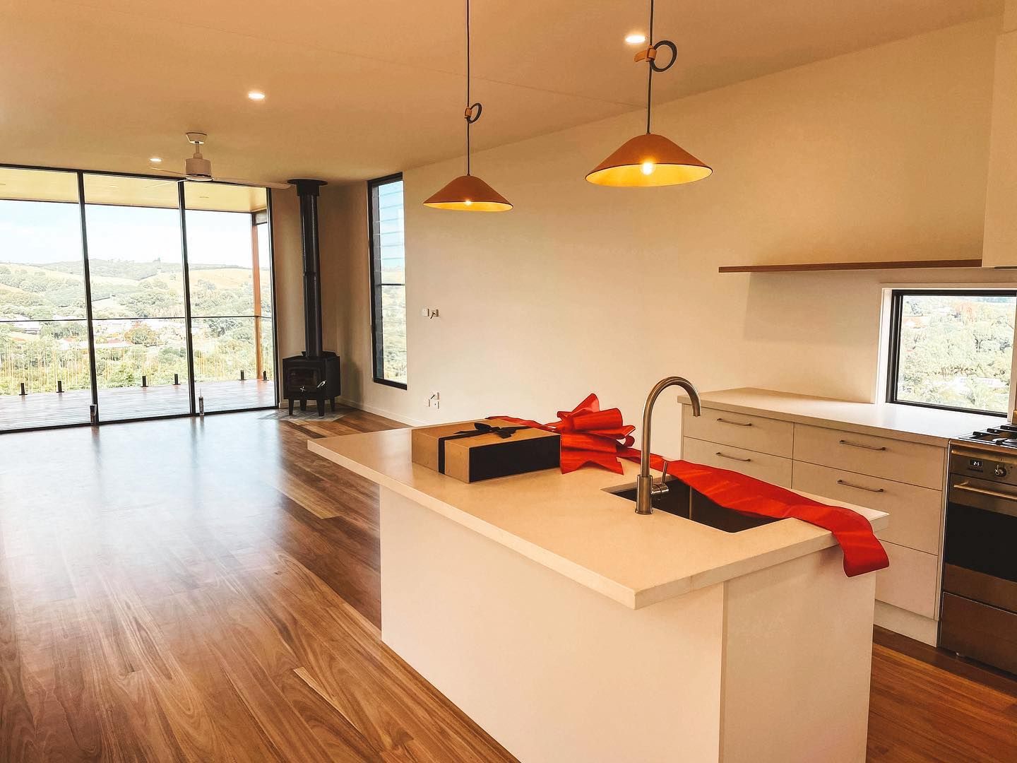An empty kitchen with a large island and a sink.
