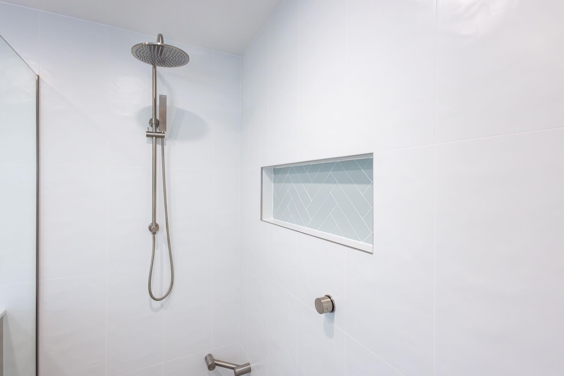 A bathroom with a shower head and a window.