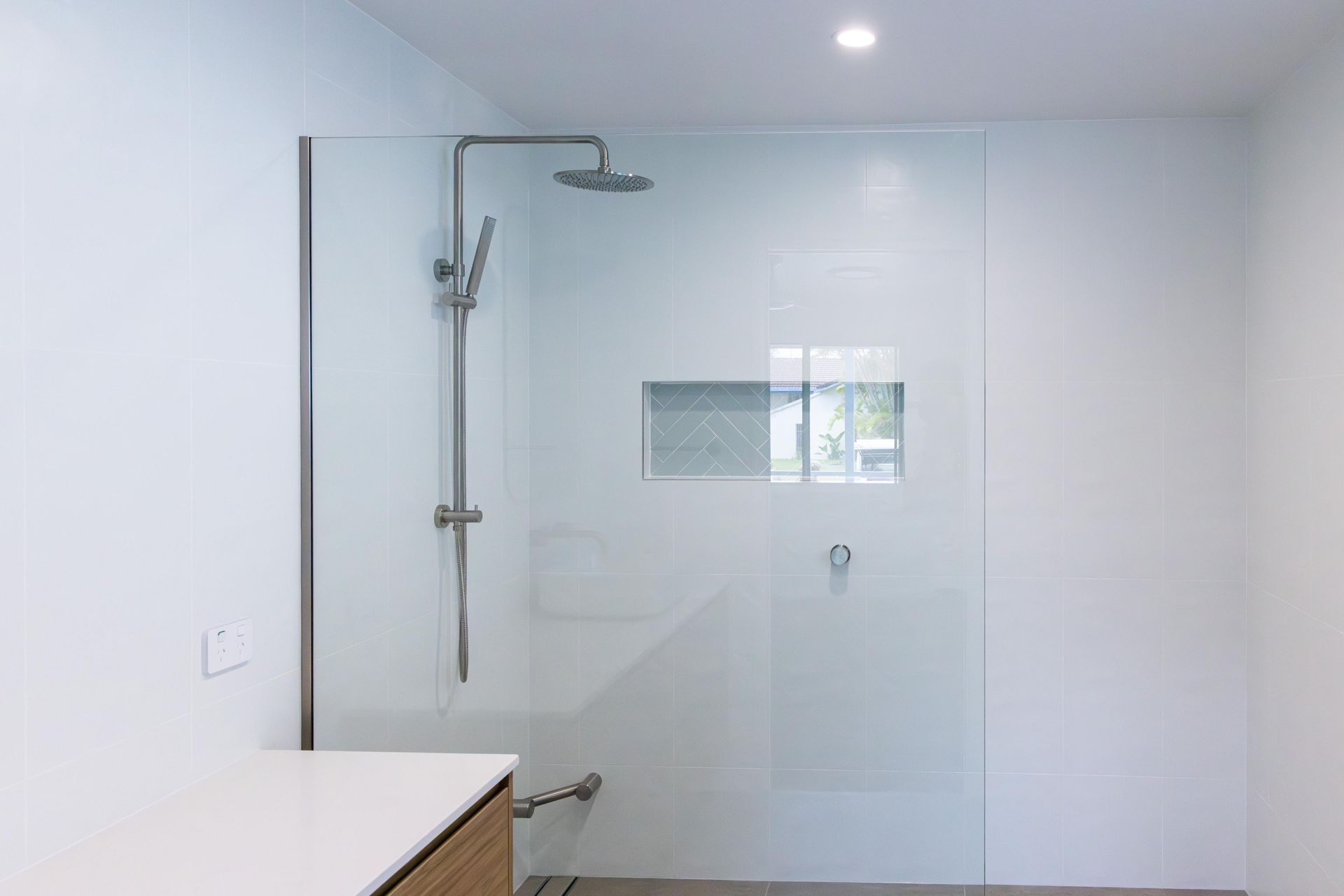 A bathroom with a walk in shower and a sink.