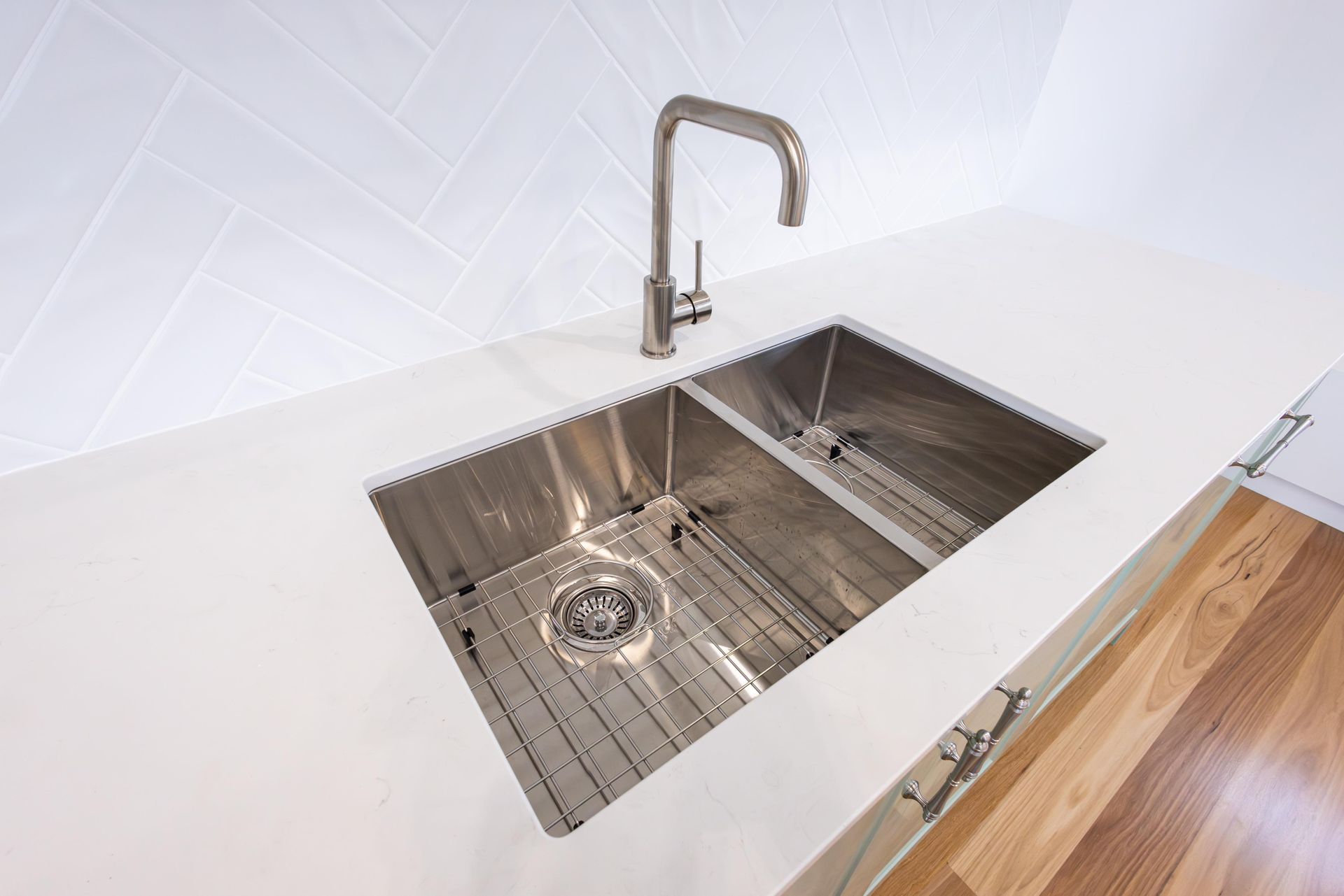 A stainless steel kitchen sink with a faucet on a counter.